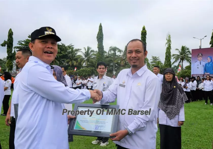 Pj. Bupati Barsel H. Deddy Winarwan saat menyerahkan Piagam Penghargaan kepada Plt. Kepala Diskominfo Kab. Barsel Mario Aan (Foto:Dok)