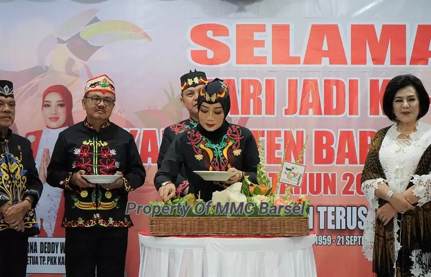 Ketua TP.PKK Kab.Barsel Hj. Erna Ardiani memotong tumpeng saat syukuran Hari Jadi ke-64 Kab. Barsel  