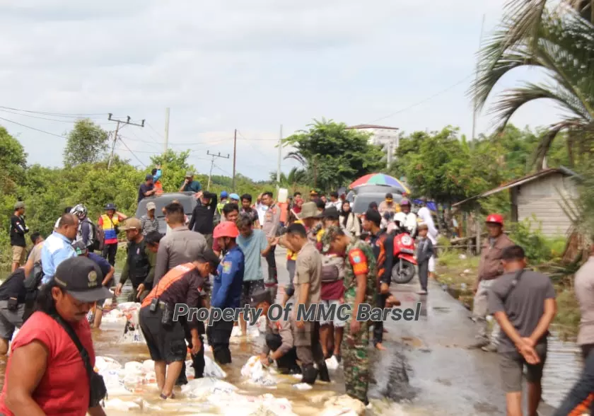 Petugas Gabungan TNI, Polri, BPBD, Damkar-Satpol PP dan warga setempat gotong royong membuat tanggul penahan air (Foto:dok)