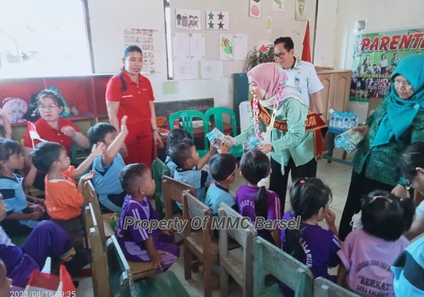 Bunda PAUD Kab.Barsel Hj. Erna Ardiani membagikan bingkisan kepada anak-anak PAUD Berkat Desa Kalahien (foto:HN2R)