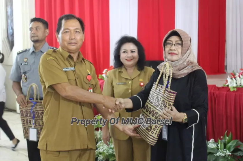 Asisten Administrasi Umum Setda Barsel  Mirwansyah menyerahkan Cindera Mata Kepada perwakilan UMKM  (Foto:R1/SNH)