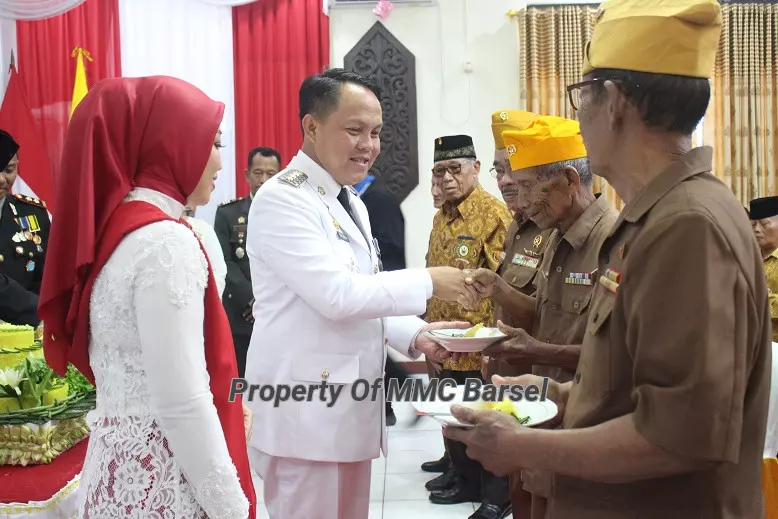 Pj.Bupati Barsel didampingi Ketua TP.PKK Kab.Barsel Hj. Erna Ardiani menyerahkan nasi tumpeng kepada Veteran dan Warakawuri sebagai Penghargaan dan rasa hormat  atas dedikasi para Pejuang (Foto:JN/R1/Elza)